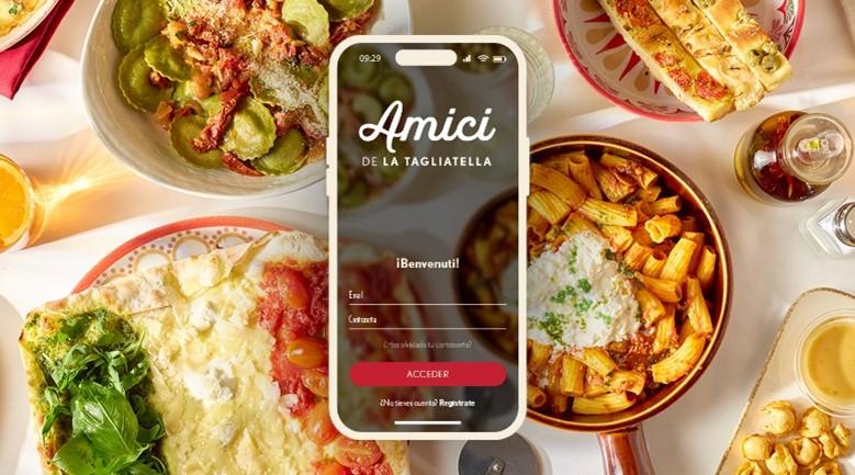Flat lay of Italian dishes including pasta, focaccia, and salad surrounding a smartphone displaying the Amici de La Tagliatella app login screen